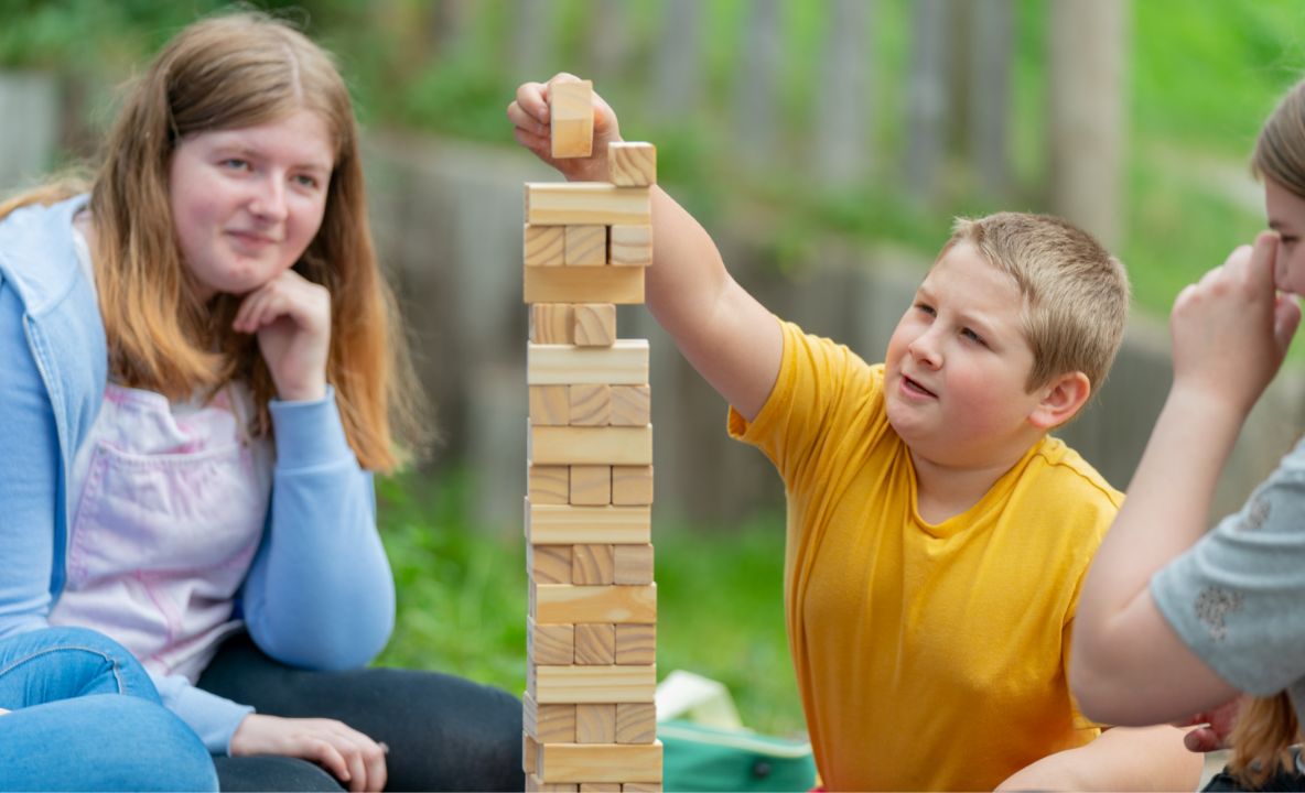 children and teen playing with jenga