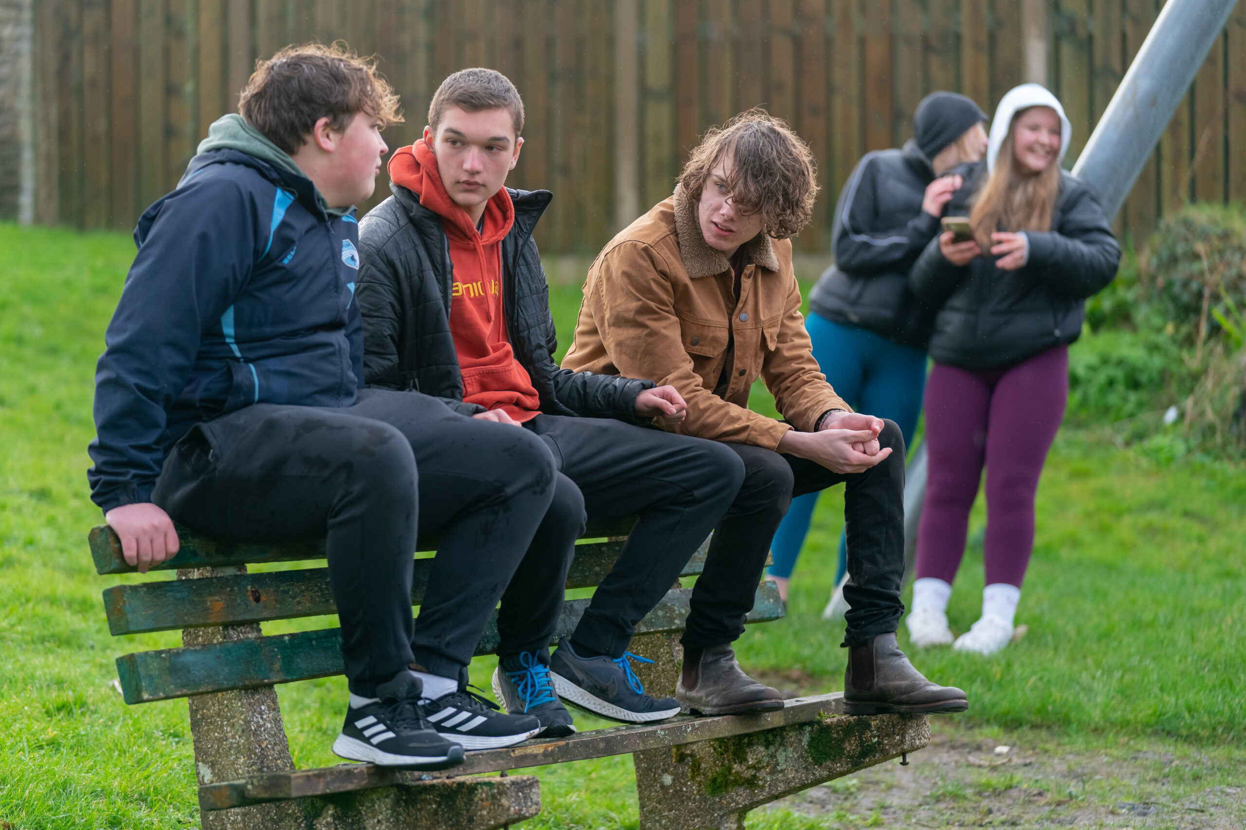 teens talking on park bench