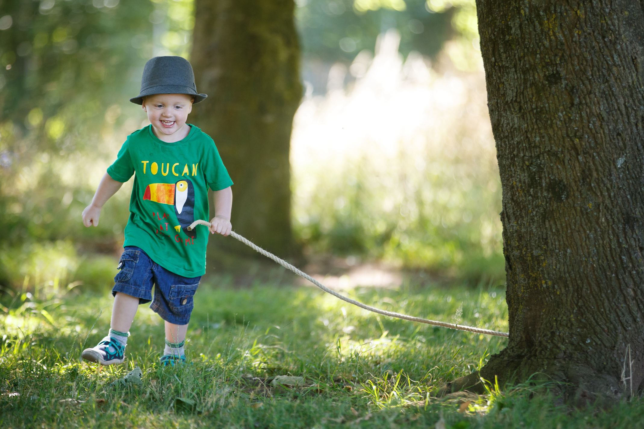 child playing with rope in woods